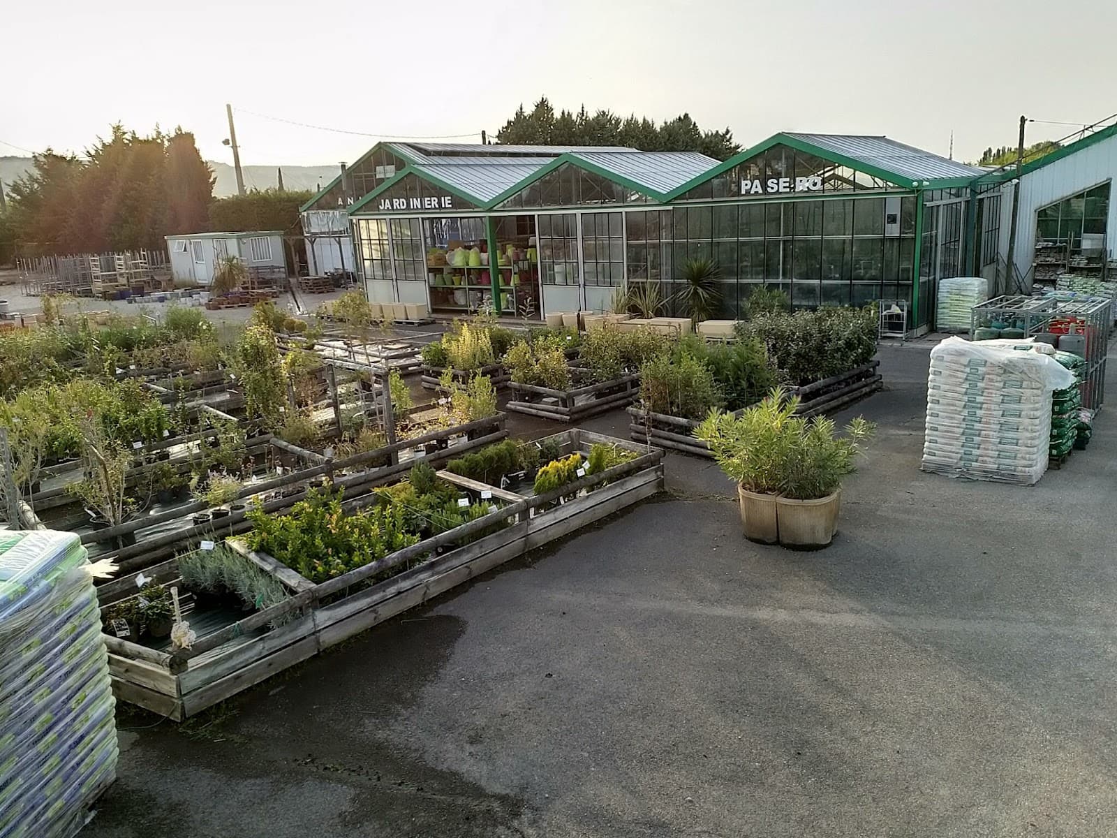 Vue extérieure de la Jardinerie Animalerie Pasero à Châteauneuf-les-Martigues, serres vertes avec allées de plantes